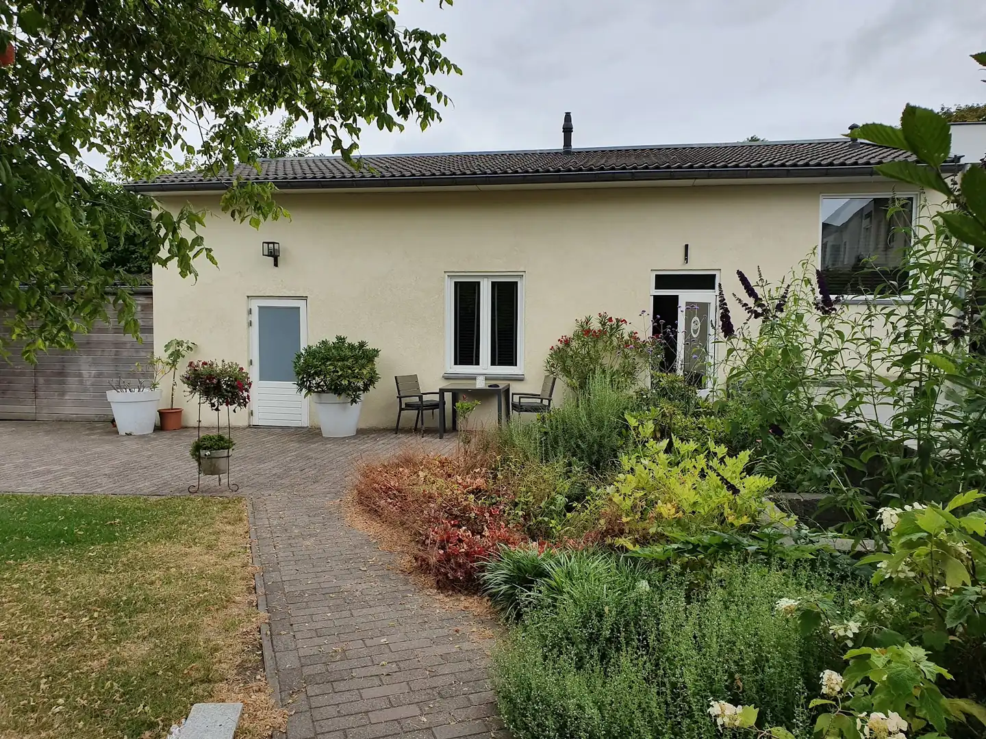 Het gastenverblijf met terras in de tuin van Les trois filles